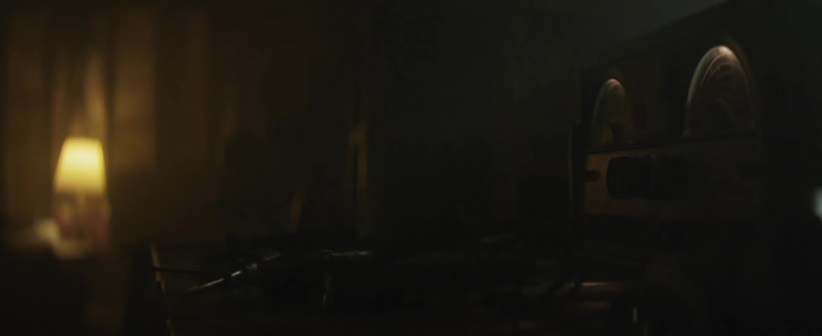 Dark room with a single electronic on a desk