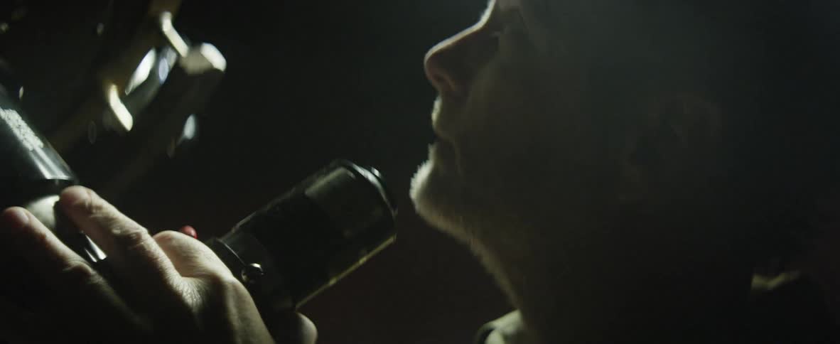 A man stands in front of the microphone and looks upward toward the spotlight