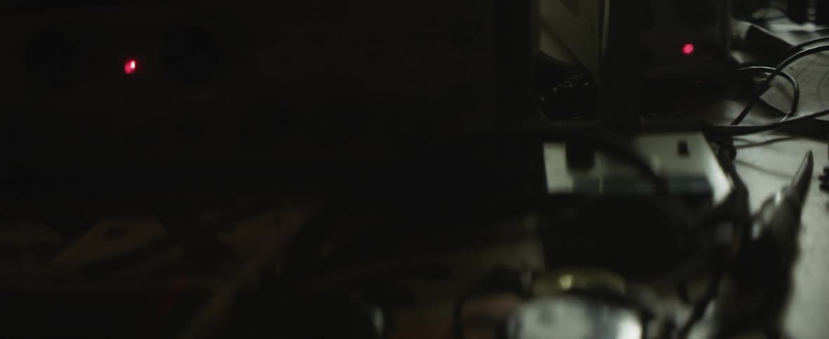 Light reflects over a dark and cluttered desk