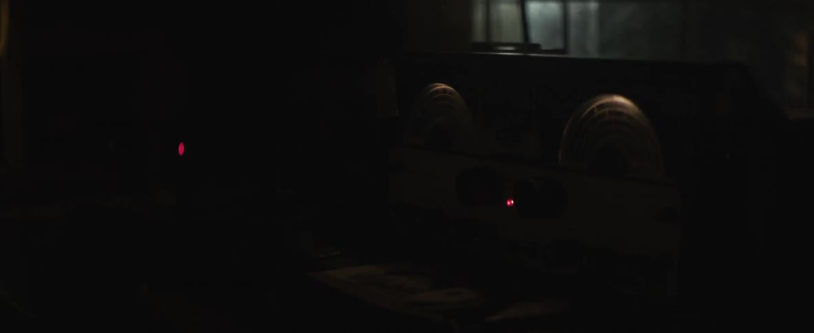 Red lights glowing on some equipment is a white light flashes by outside