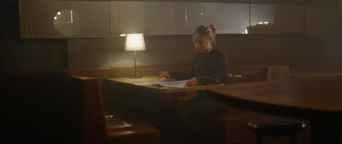 A woman is reading the newspaper in the restaurant
