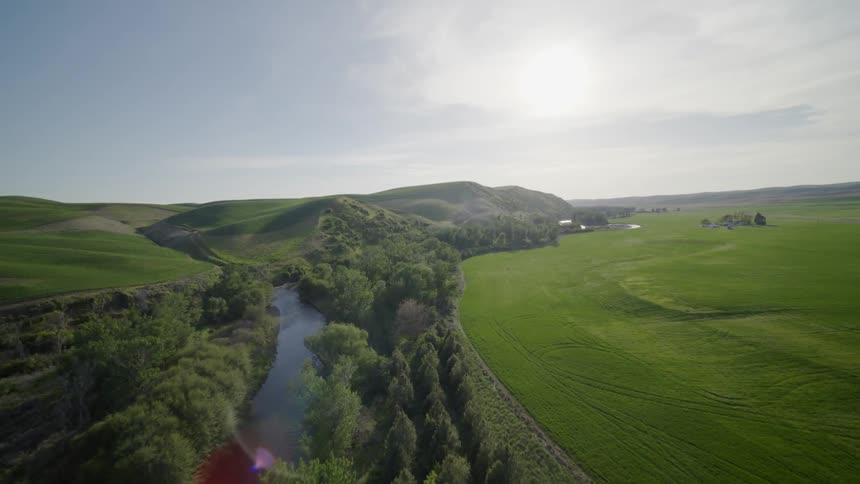 Flying over a fertile and lush farmland river valley