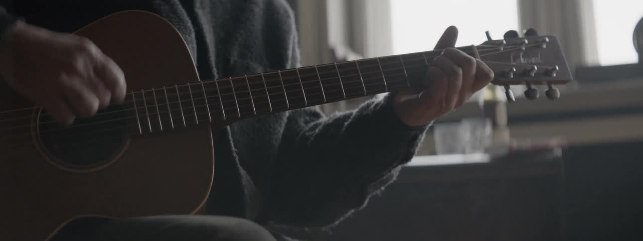 A person plays the acoustic guitar