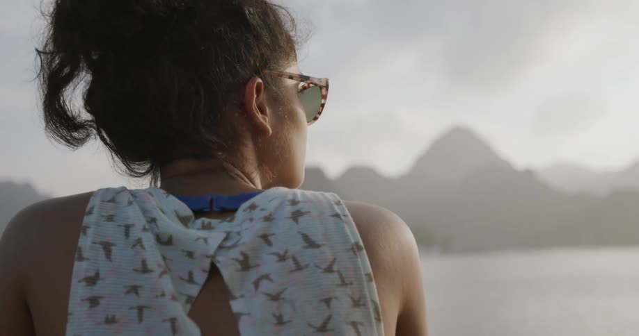 A young woman looks out towards the water