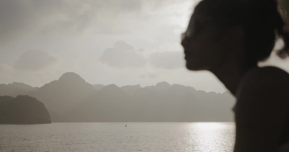 Woman looks at a mountain lake