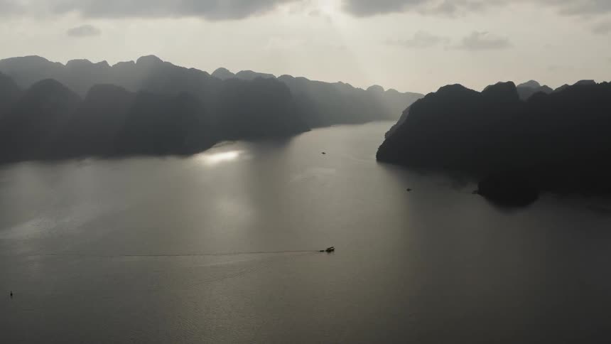 The boat is moving in the large lake at sunset