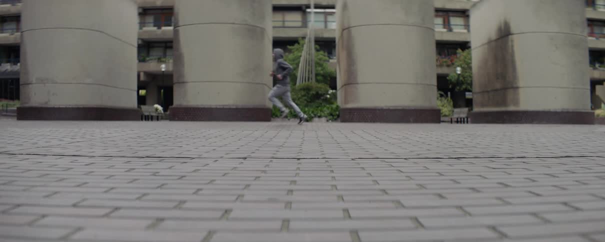 An empty bag is blown across a city sidewalk