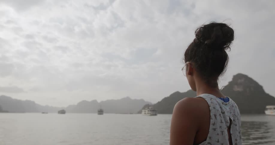 Woman looks at boats on a mountain lake