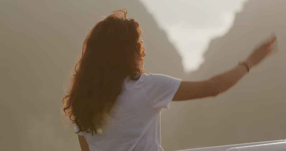 A woman waves on a foggy day