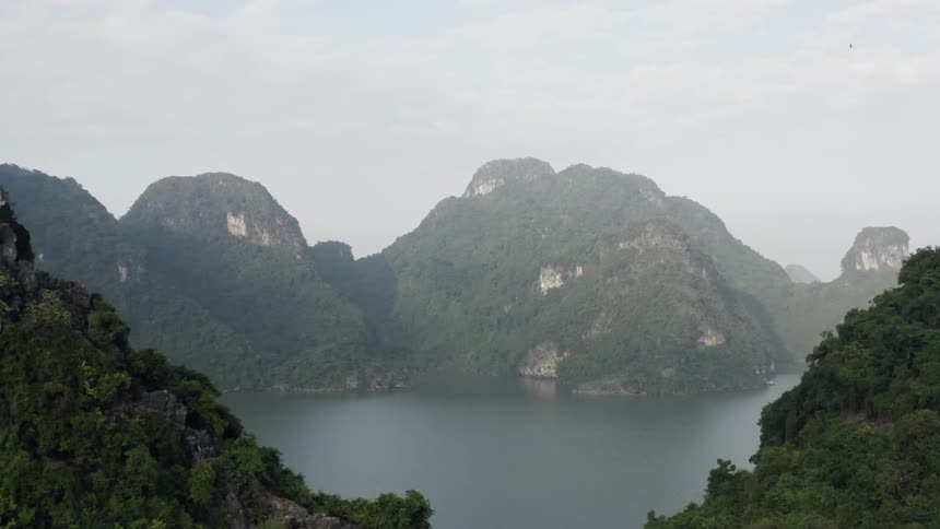 Clouds roll over water and grassy hills