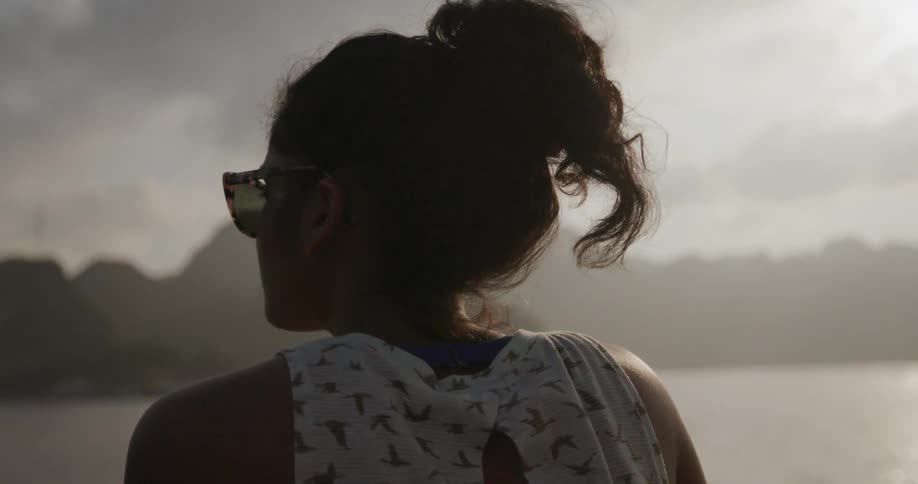 The woman looks around by the lake at dawn