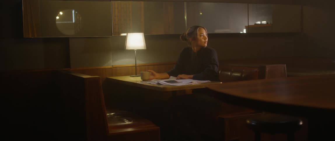 A woman sits alone at a restaurant booth