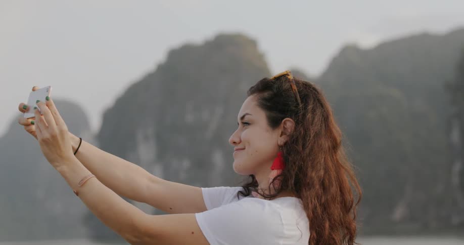 A woman is taking photos from a boat with her phone