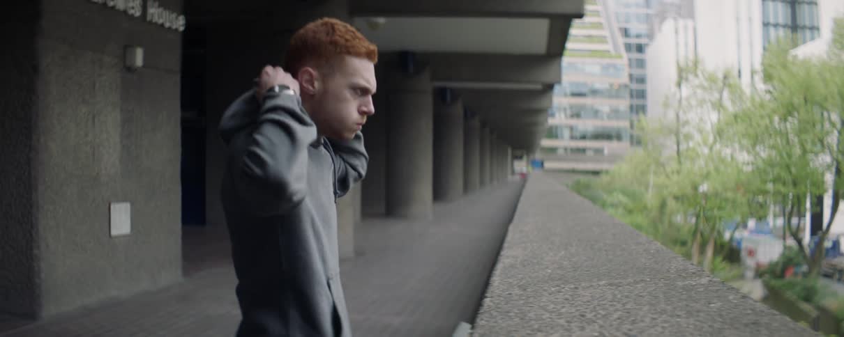 A man puts his hood up and jogs off