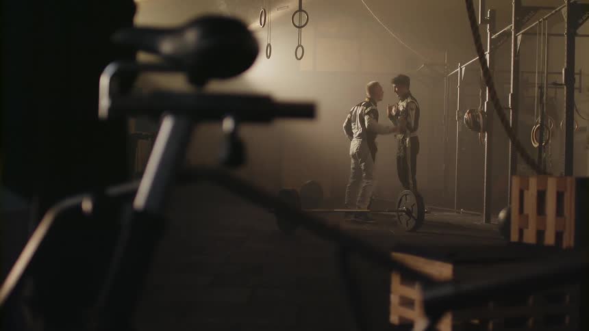 Two men argue and push each other in a gym