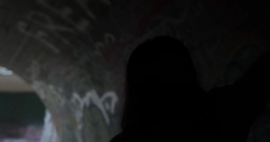 Woman moves her arms around as she stands in a tunnel