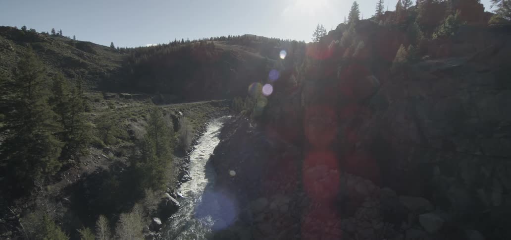 A stream flows between hills on a sunny day