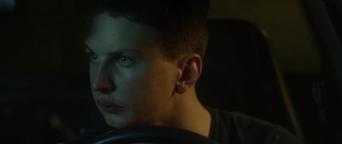 A man looks out from the front car seat