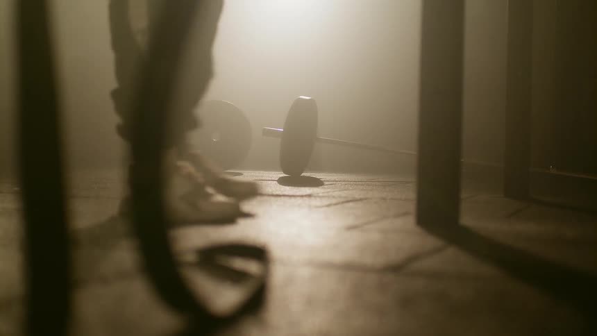 Man walks near the dumbbells laying on the floor