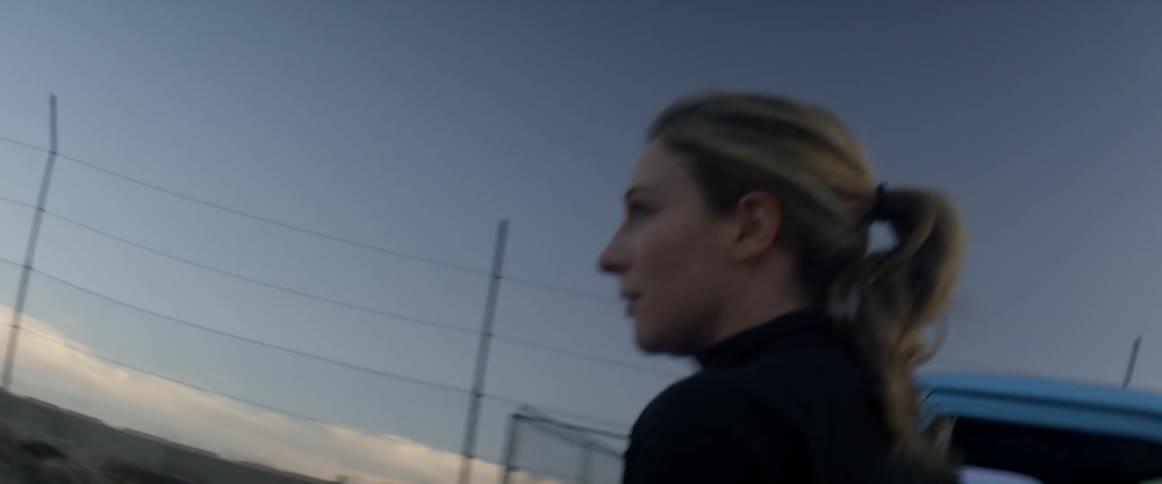 A woman runs alongside a blue pickup truck