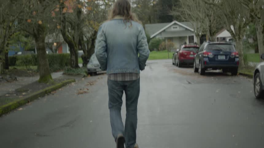 Man walks in a neighborhood on a cloudy day