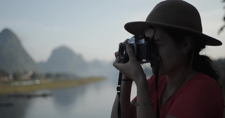 Woman takes a picture of nature with a camera