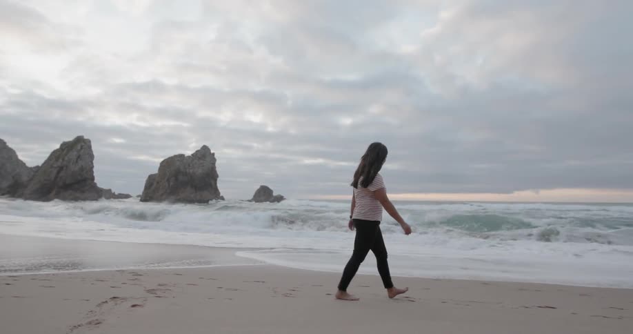 A woman walks on the beach