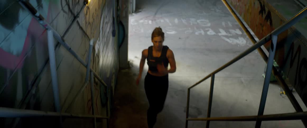 The woman runs fast up the stairs in the building