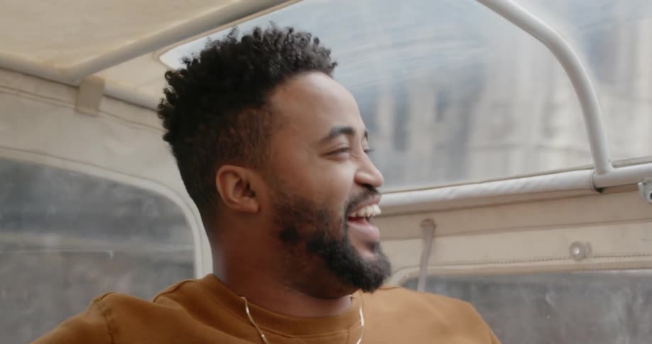 A man and woman laugh as they ride through a city