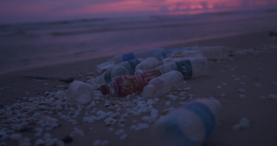 The shore is covered with many plastic bottles at dawn