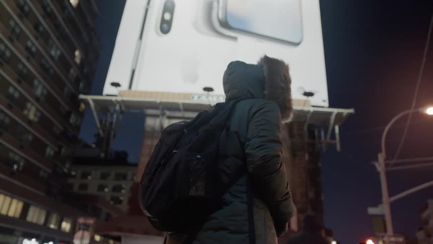 Woman stands on a city street in a heavy coat