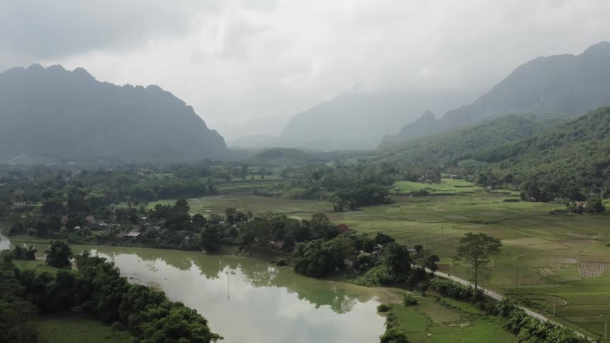 Clouds hang above the mountain and river