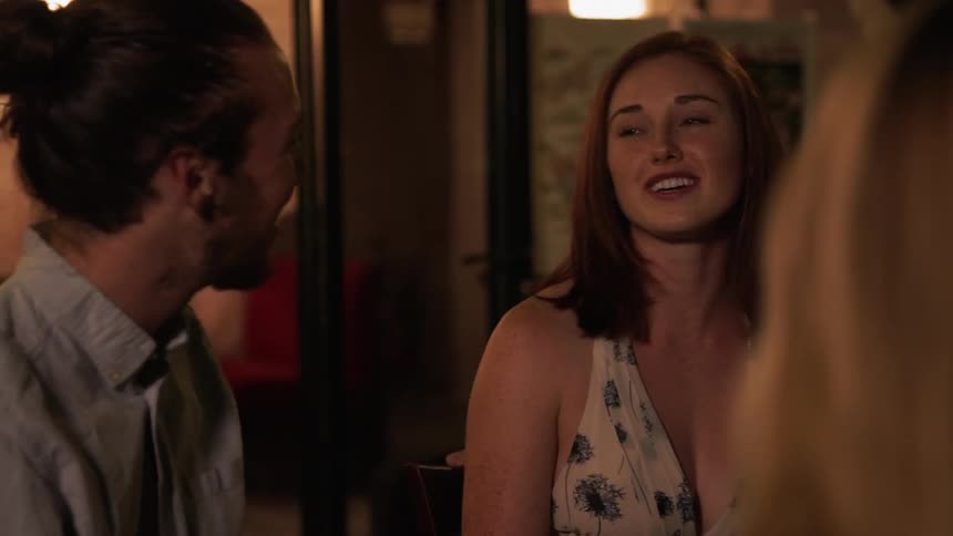A man and woman converse inside a restaurant