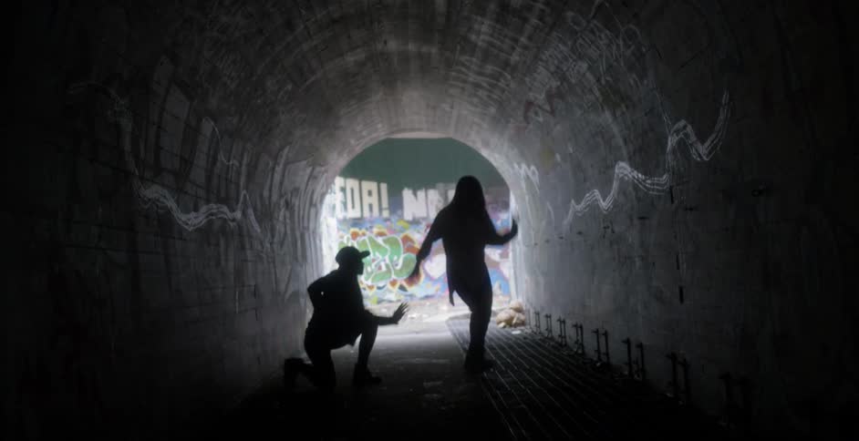 Two women dance in a tunnel in the city