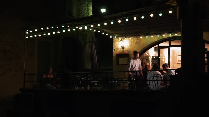 A man is greeted on a restaurant patio