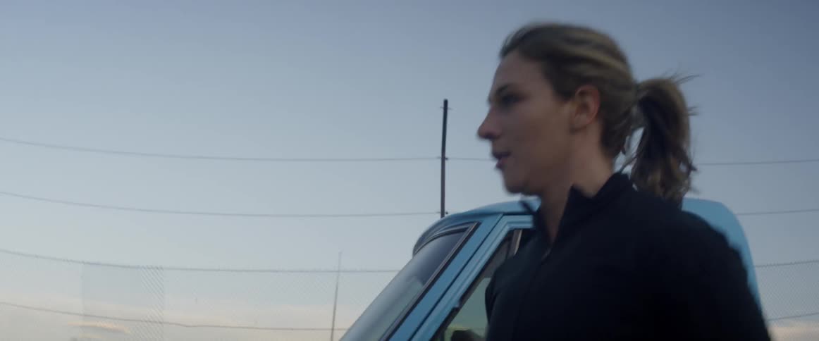A woman runs alongside a blue pickup truck