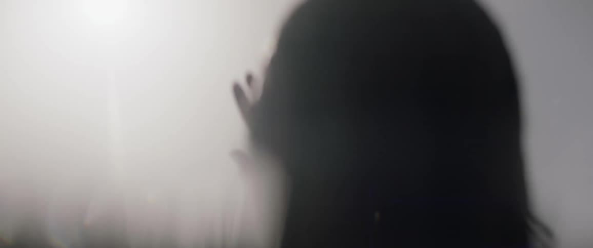 A woman sticks their arm out of the neck deep water