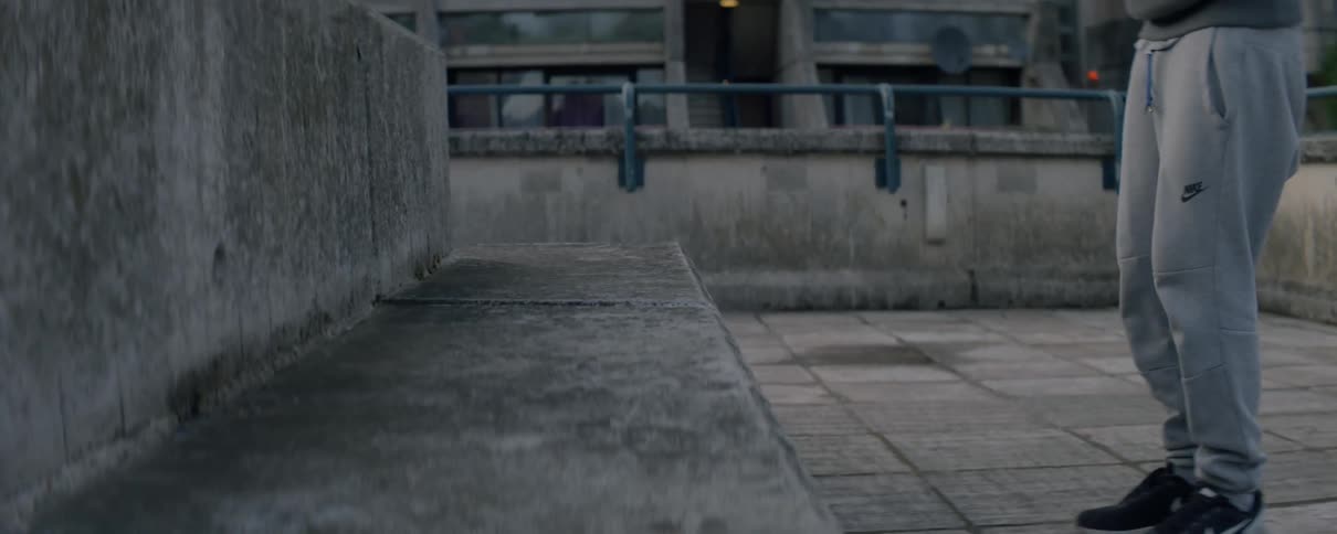Man is jumping up and down on concrete bench in city