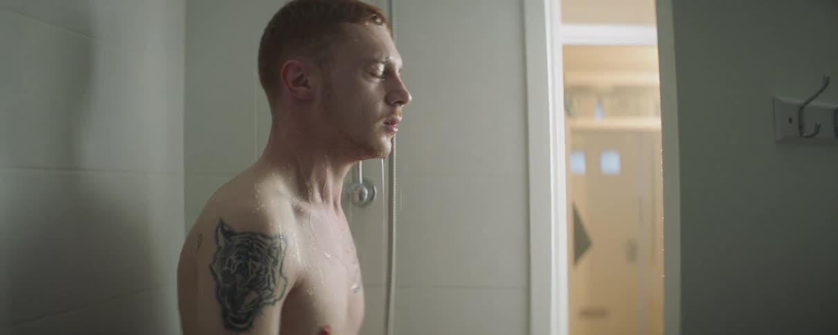 Man lets water run over his face in a shower