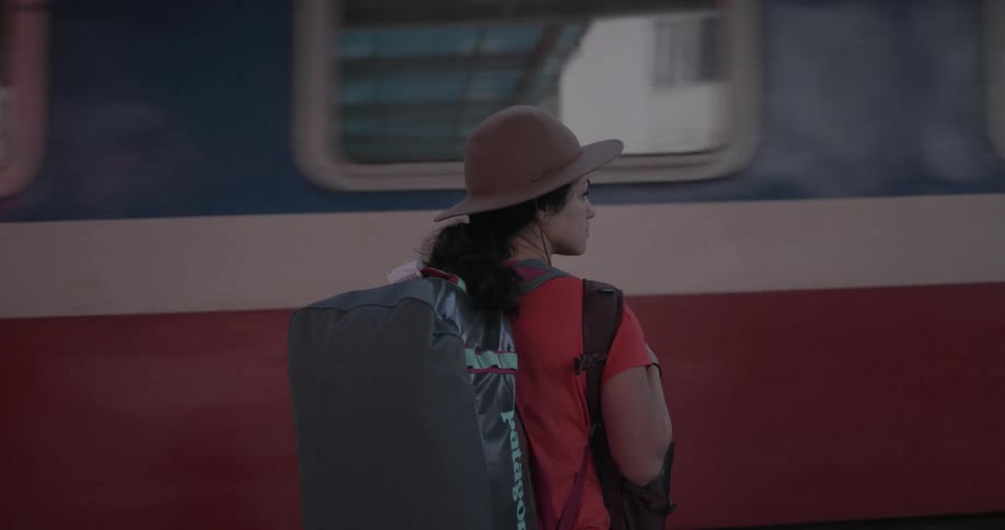 Woman stands in front of a moving train