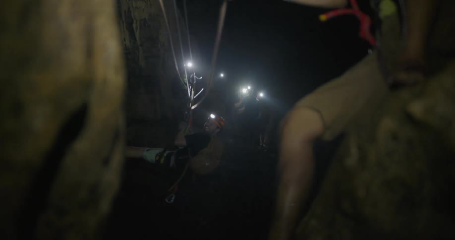 A man is pulled on a zip line inside a cave