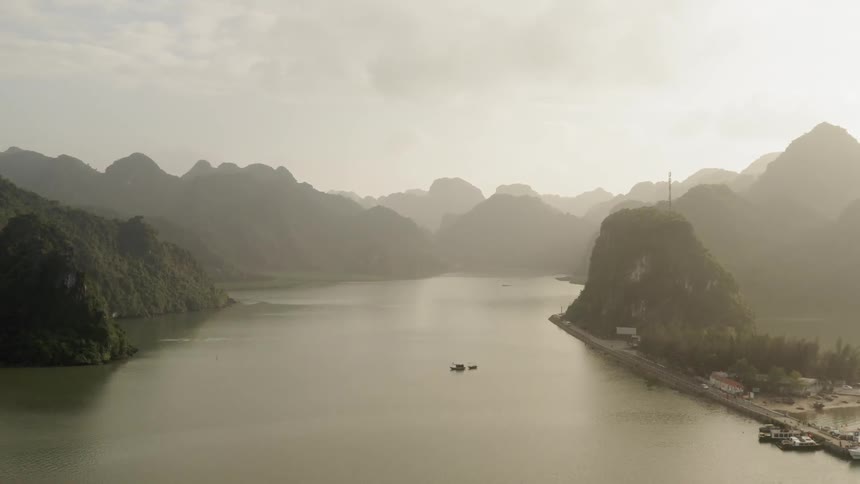 The sun shines on the water near mountains