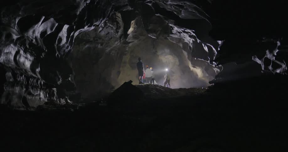 A group of people explore a dark cave
