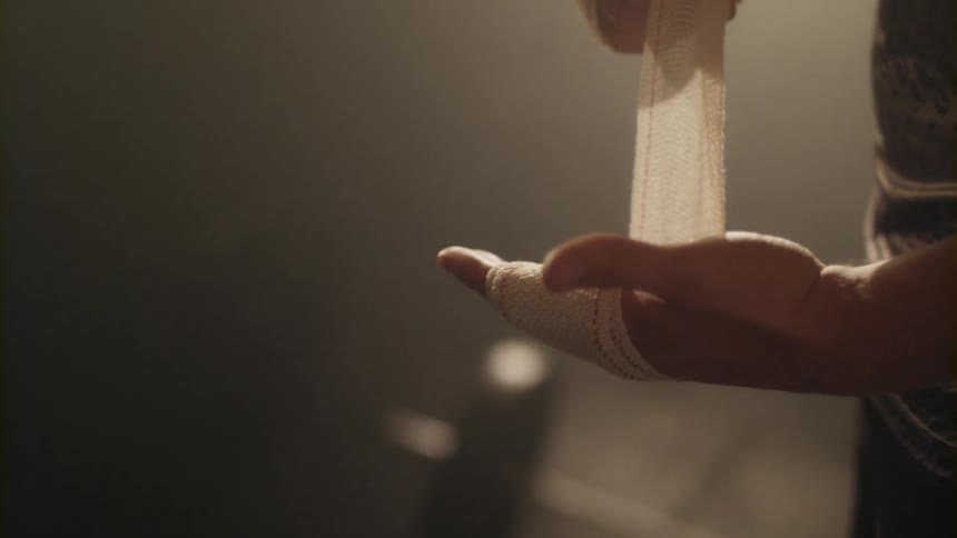 A man wraps his hand with cloth