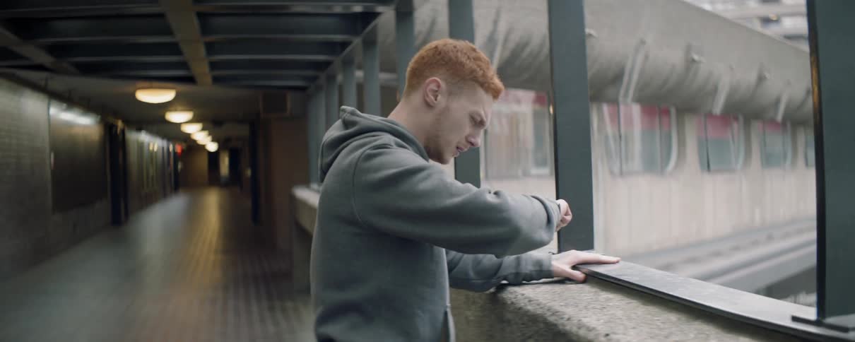 A man wipes his face near the railing
