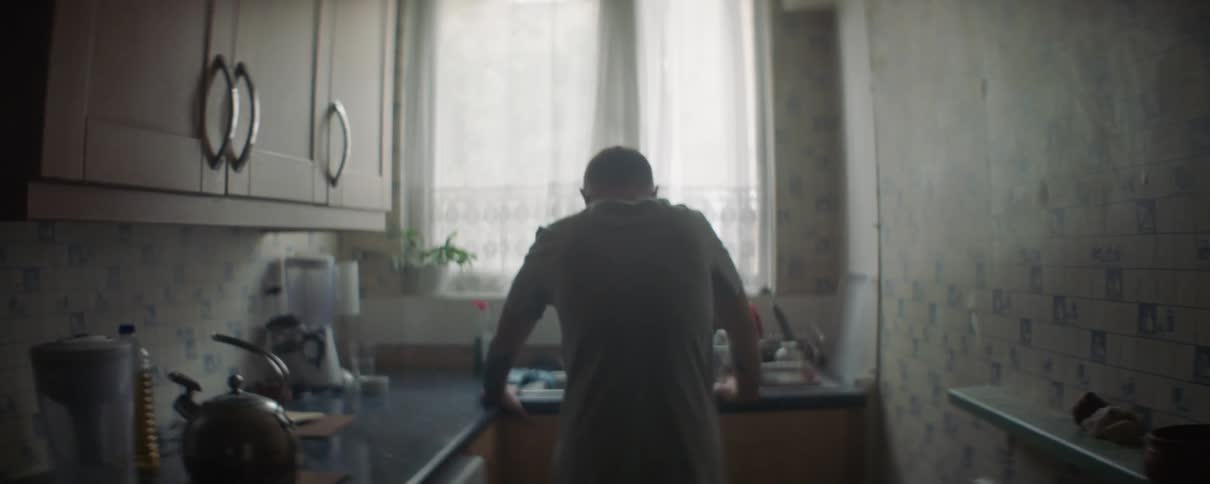 A man leans on the kitchen sink