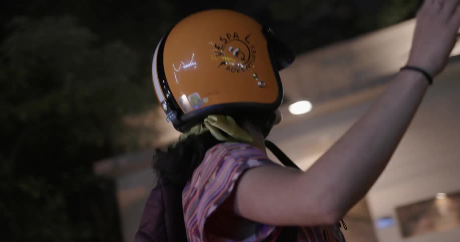 Two people ride on a motorcycle at night