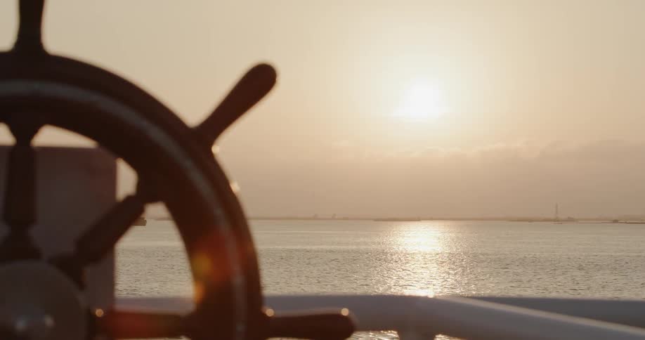 A boat floats on water at sunset