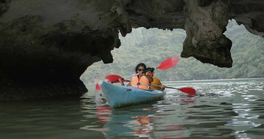 Two young women row a boat on the water