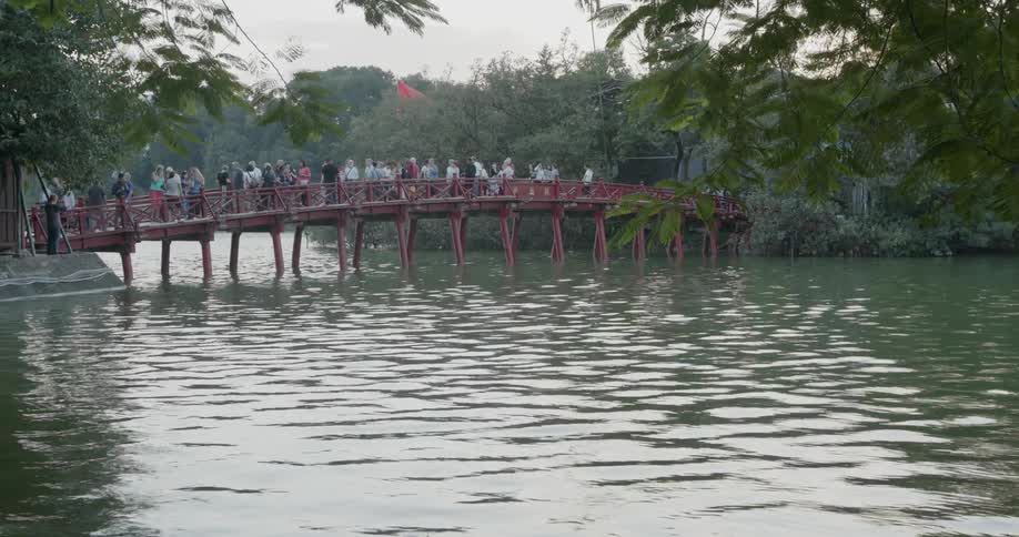 Crowd of people walk over a bridge
